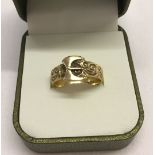 A 9ct gold buckle ring with scroll design. Size R. Total weight 3.9g.