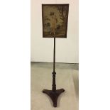 A tapestry pole screen with wooden base and classic lady design.