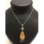 A carved dog face pendant set with a citrine and an amethyst, stamped 925, on a rope chain.