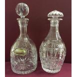 2 cut crystal decanters one with a HM silver whisky label.