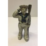 A modern reproduction cast iron money box in the shape of a sailor.
