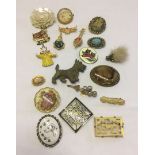 A collection of costume brooches to include agate set spinx oval brooch and early plastic dog