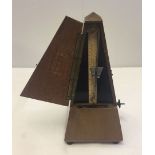 A fully working French metronome, one foot missing from base.