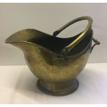 A large brass coal scuttle with handle.