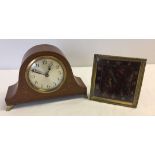 A brass clock with tortoiseshell effect face together with a small wooden cased mantle clock.