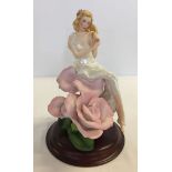 A ceramic figure on wooden base 'Lady Rose' by Jegou made by the Franklin Mint.