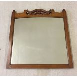 Edwardian bevel edged mirror in wooden frame with carved detail to top. Frame size 59 x 63cm.