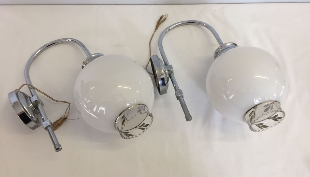 A pair of wall lights with round white shades.