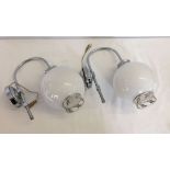 A pair of wall lights with round white shades.