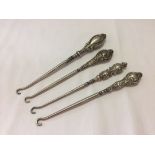 Four silver handled hallmarked button hooks. Various makers. Between 170mm and 190mm.