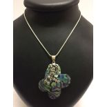 A flower shaped abalone shell pendant set with a blue topaz. With 925 silver butterfly and flower