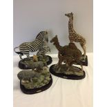 4 resin animal ornaments on wooden plinths: 1) Zebras, 2) Giraffe, 3) Camels, and 4) Wolves.