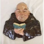 A Friar Ware wall hanging plaque of a monk reading, signed N. Alexandre.