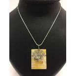 A rectangular shaped shell pendant with a 925 silver bale and turtle motif, on a rope chain.