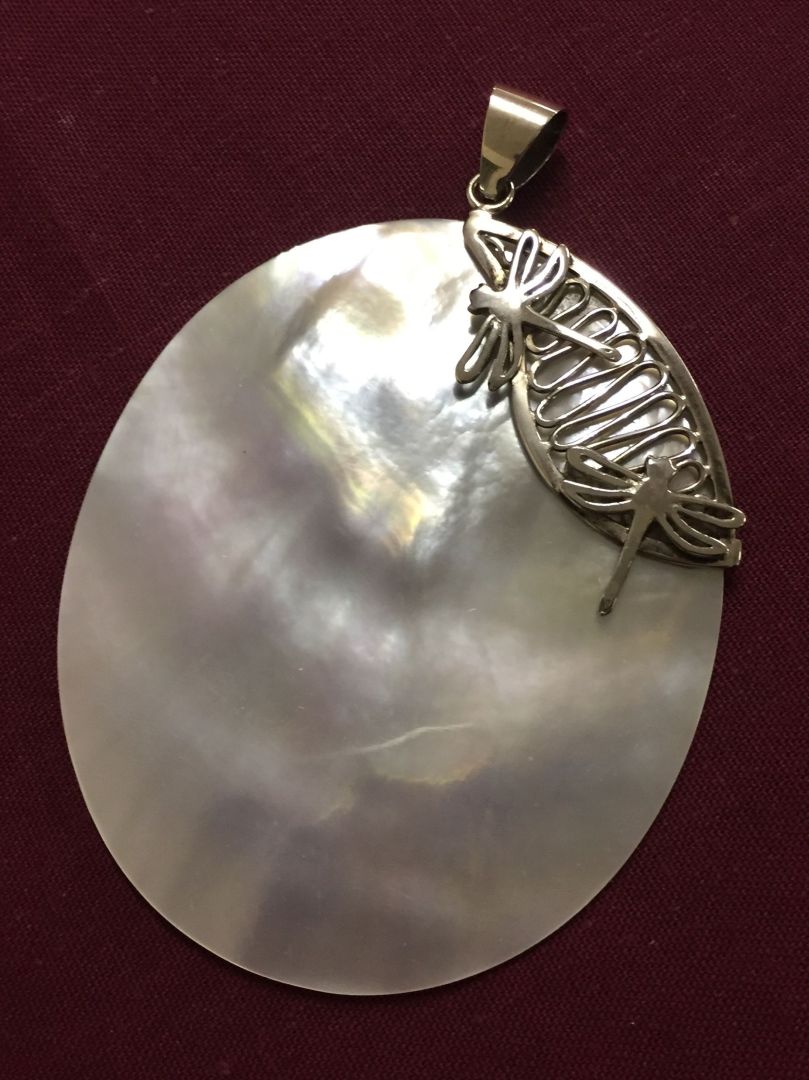 A mother of pearl shell pendant witht 925 silver bale and dragonfly motif.