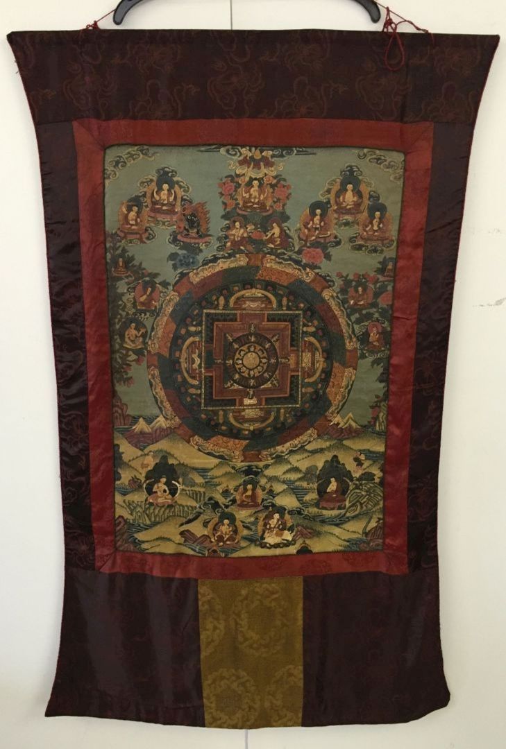 A mid 19th century Tibetan Thangka. Highly decorated central panel with hand painted deities