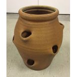 Terracotta strawberry pot, 16" tall together with terracotta herb pots in a wooden carrier.