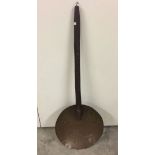 A large wooden handled copper strainer.