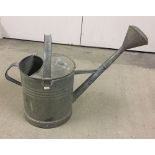 A galvanised watering can with rose.