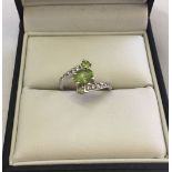 A 925 silver twist design dress ring set with large central peridot, 2 smaller peridot stones and