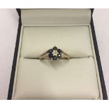 A 9ct gold dress ring set with 6 sapphires and central diamond. Size P, weight approx 2g.