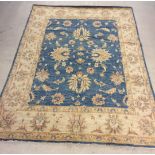 A large cream & blue rug, originally from Jarrolds Norwich. Approx 159cm x 236cm