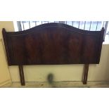 A modern mahogany king size headboard with curved top, column and finial detail.