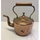 A vintage copper kettle with metal handle.