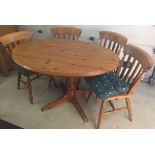 An oval pine kitchen table together with 4 matching chairs.