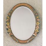 An ornate gilt and painted oval dressing table mirror.