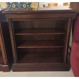 A solid flame mahogany bookshelf with moveable shelves & column design to front. Approx 92 x 94cm.