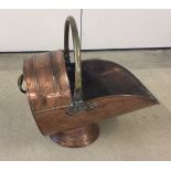 A copper coal scuttle with insert for scoop.