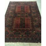 A large rug in deep red & green colours. Approx 169cm x 261cm with fringe.