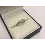 A 9ct gold dress ring set with a square cut blue topaz and small diamonds to shoulders size N.