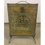 A brass fire screen with galleon and ivy design to front.