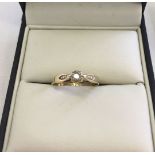 A 9ct gold ladies ring set with a solitaire diamond and illusion effect down each shoulder. Size O.