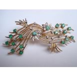 A diamond and emerald set yellow metal spray brooch, 8cm long.