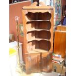 An early 20th Century stained pine standing corner cupboard,
