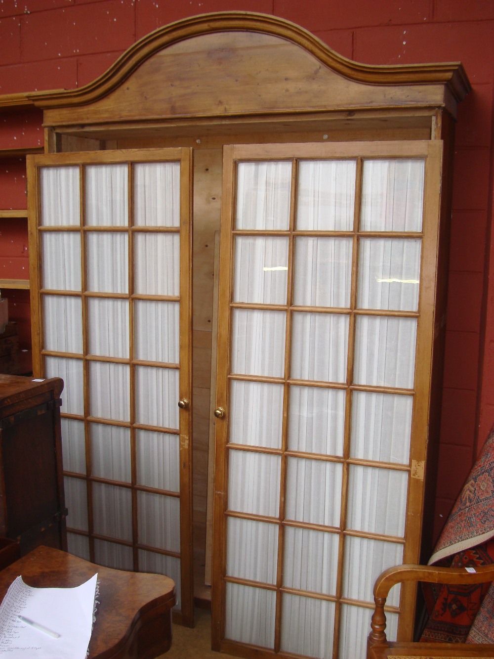 A large French pine trophy cabinet/wardrobe with glazed doors.