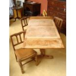 An oak draw leaf table and three chairs.