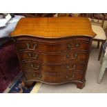 A 20th Century serpentine fronted bachelors chest of drawers with brushing slide over four