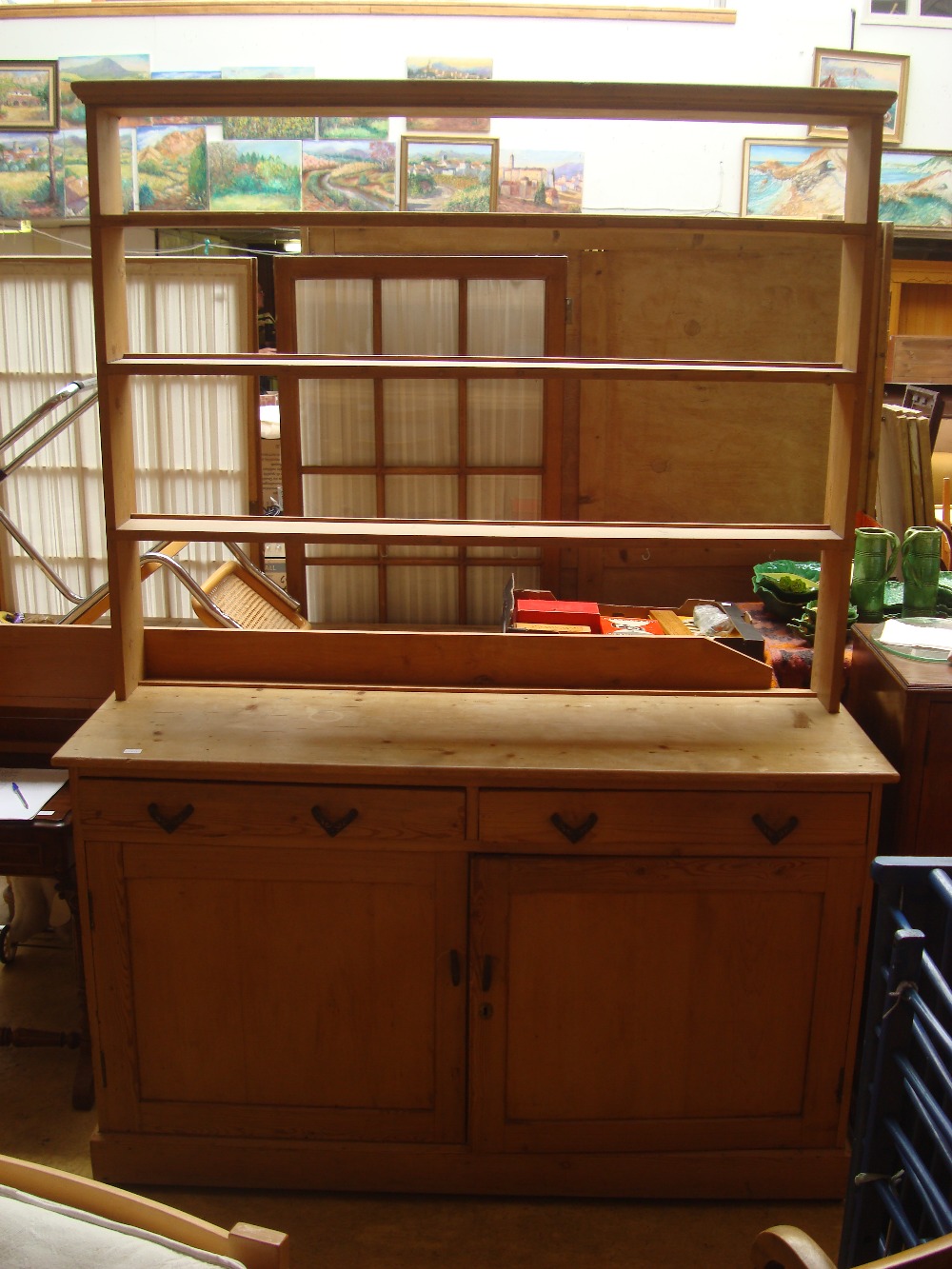 A pine dresser with plate rack, the body with two cupboards and two short drawers.