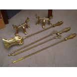 A set of brass fire irons with two brass fire dogs.