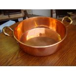 A twin handled copper pan.