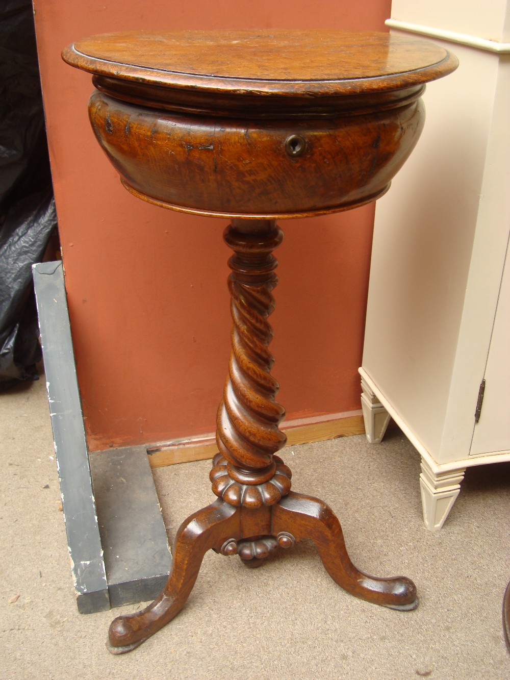 A 19th Century sewing box/work table, the circular top raised on a heavy twisted stem.