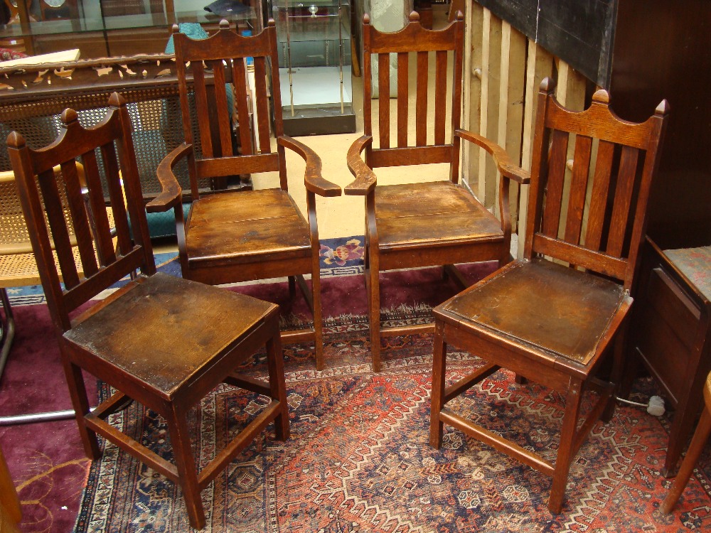 Four late 19th Century semi Gothic oak dining chairs.