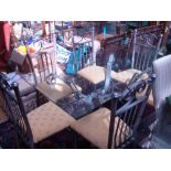 A glass top table with metal stand and six matching chairs.