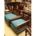 A Bergere style oak framed two seater sofa with carved top rail on bun feet,