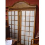 A large French pine trophy cabinet/wardrobe with glazed doors.