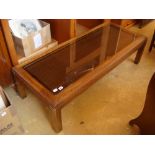 A low coffee table with inset glass top.